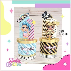 May include: Two gold and black striped cake stands with a gold top. Each stand has a doll on top. The doll on the left is a blue-haired doll with a pink and blue dress. The doll on the right is a blonde doll with a black and yellow dress. Both dolls have the name "Isabella" and the number "4" on their stands.