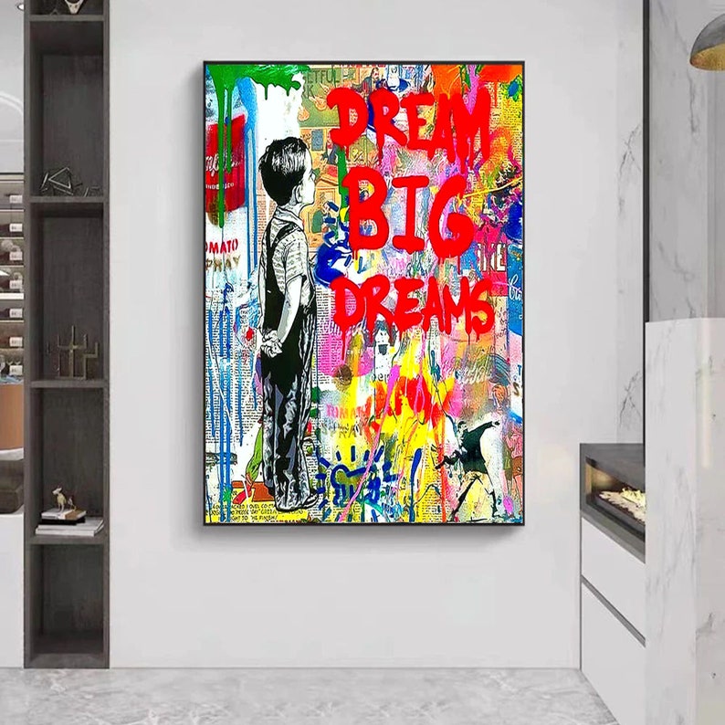 K&ouml;nnte beinhalten: Ein farbenfrohes abstraktes Gem&auml;lde mit einem jungen Jungen, der vor einer Wand steht, auf der die Worte "Dream Big Dreams" in roter Farbe geschrieben sind.