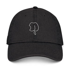 May include: Black baseball cap with a white outline of a stylized shape on the front. The cap has a curved brim and a button on top. The hat is made of a soft, textured fabric.