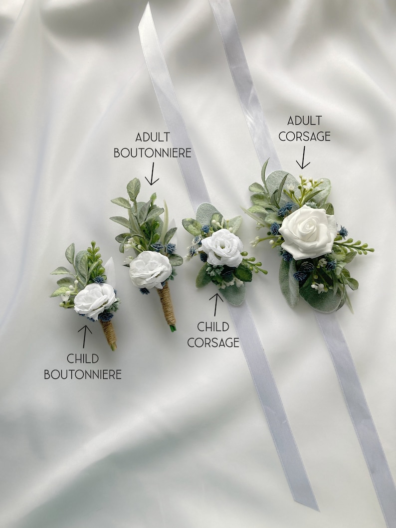 K&ouml;nnte beinhalten: Vier wei&szlig;e Blumen-Boutonni&egrave;res und Corsagen mit Gr&uuml;n und blauen Akzenten. Der Text "Erwachsene Boutonniere", "Erwachsene Corsage", "Kind Boutonniere" und "Kind Corsage" ist auf dem Bild zu sehen.