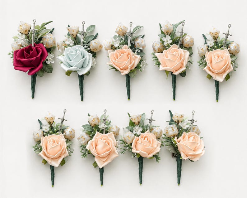 May include: A collection of nine floral boutonnieres featuring a single rose, green foliage, small white flowers, a silver sword charm, and several polyhedral dice. The roses vary in color, including deep red, light blue, and shades of peach.