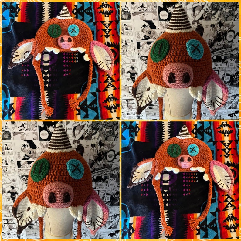 May include: A crocheted hat shaped like a monster with brown, green, and pink details. The hat has long, dangling strings and a wide brim.