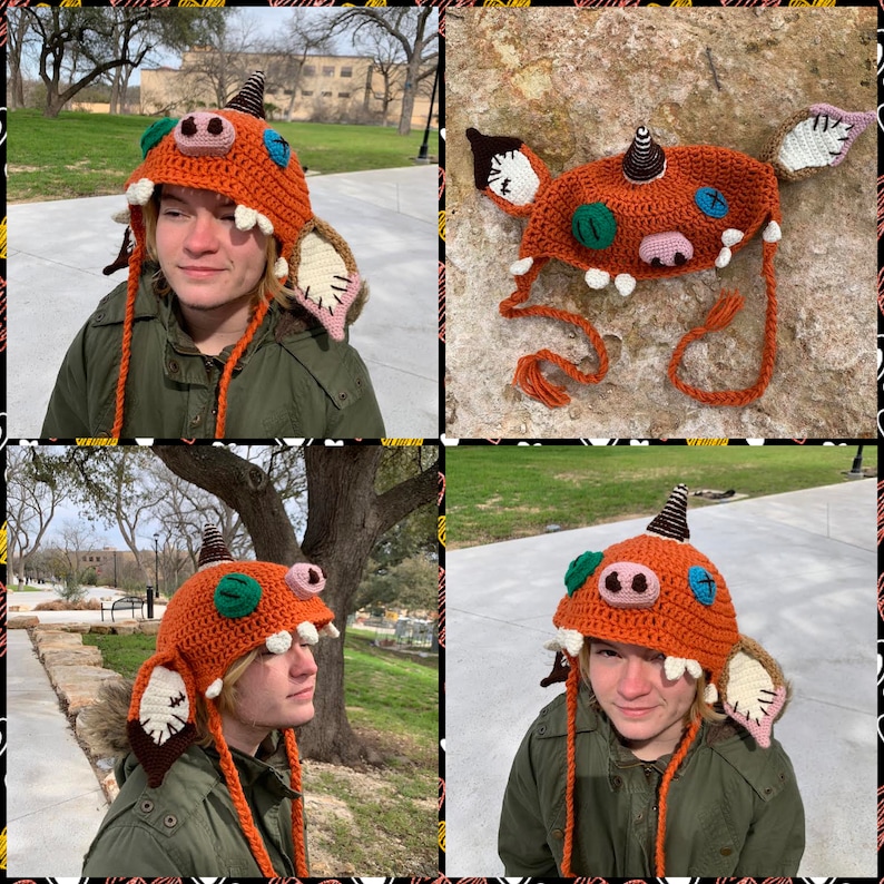 May include: A crocheted orange and brown monster hat with green and blue eyes, a pink nose, and white teeth. The hat has long orange and brown ties and floppy ears.