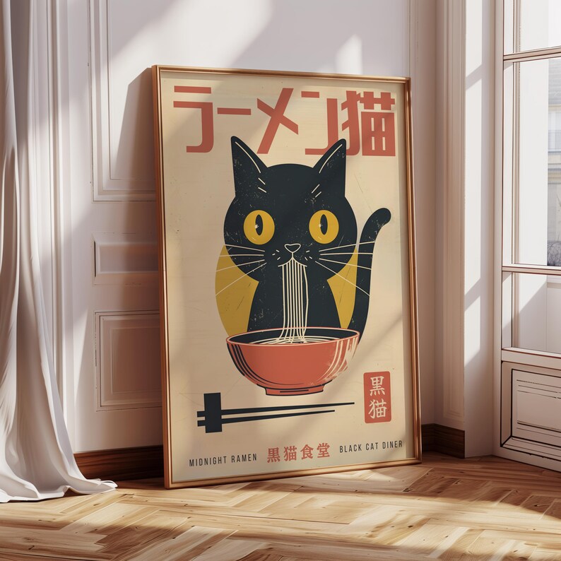 May include: Framed poster featuring a black cat eating ramen from a red bowl. The cat has yellow eyes and is set against a beige background with Japanese text. The poster is in a gold frame and includes the text "Midnight Ramen" and "Black Cat Diner".