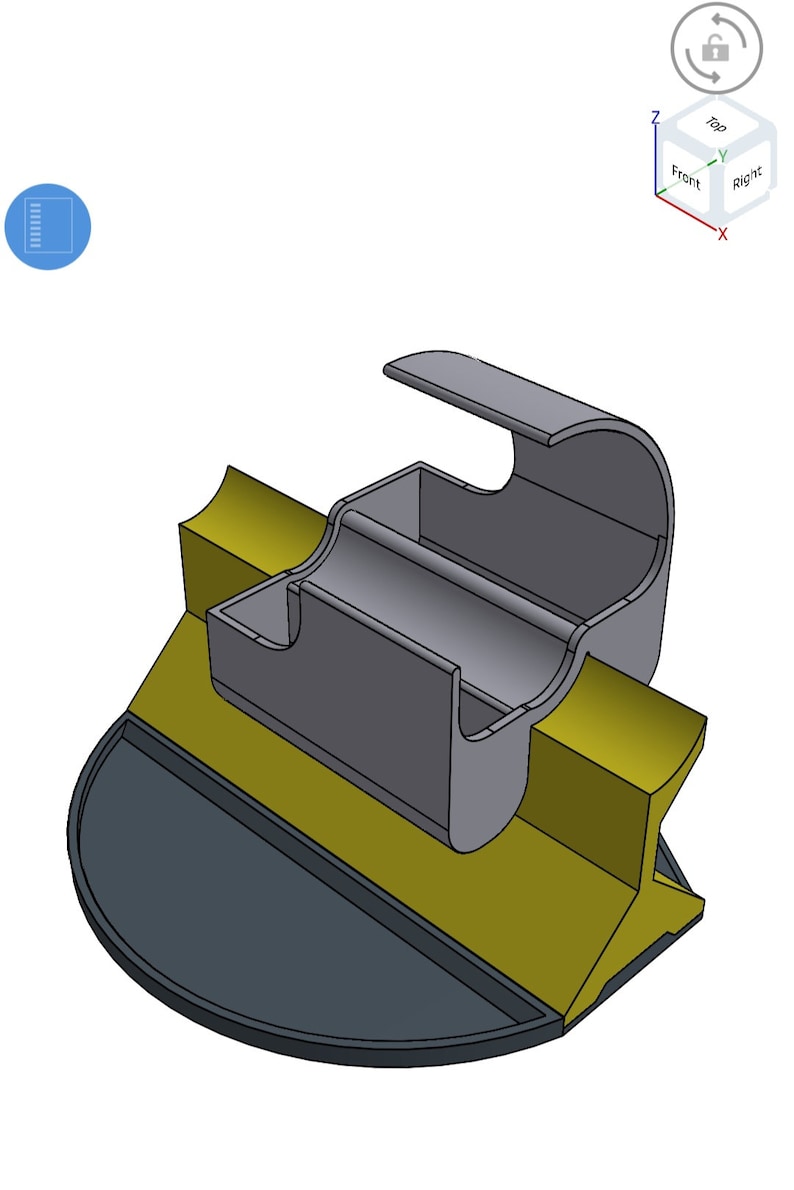 May include: A 3D model of a grey and gold phone stand with a curved top and a base. The stand is designed to hold a phone upright and has a small compartment for charging cables.