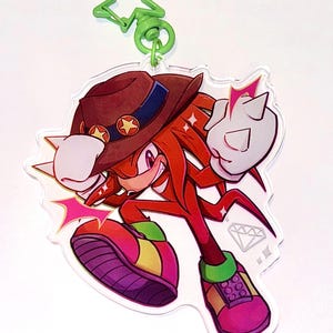 May include: A red and yellow cartoon character with a brown hat and a diamond charm. The character is wearing red shoes with yellow and green accents. The character is in a fighting pose with a red and white starburst behind it.