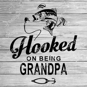 May include: Black and white graphic design with a fish jumping out of the water and the text "Hooked on being Grandpa" with a fishing lure underneath.