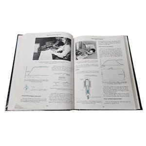 May include: An open book with black and white illustrations and text. The book is titled "Electricity and Basic Electronics." The pages show diagrams, schematics, and photographs related to electronics and electrical circuits.