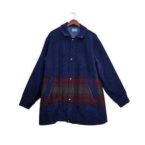 Peut inclure: Une veste à manches longues avec une texture semblable à de la laine bleu foncé et un motif à rayures horizontales bordeaux, vert foncé et gris sur la partie centrale. La veste comprend un col rabattu, une fermeture à boutons-pression et deux poches.