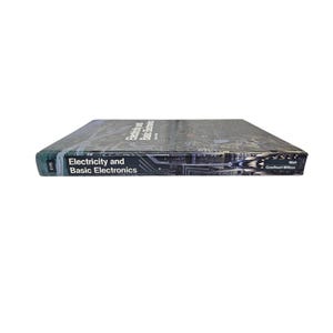 May include: A textbook titled "Electricity and Basic Electronics" is shown in a low-angle shot. The book has a dark cover with a circuit board design. The spine displays the title and the number "0175".