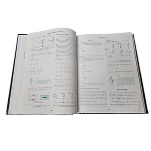 May include: An open textbook on a white surface, featuring diagrams and equations related to electricity and basic electronics. The pages display text and illustrations of circuits and electrical components.