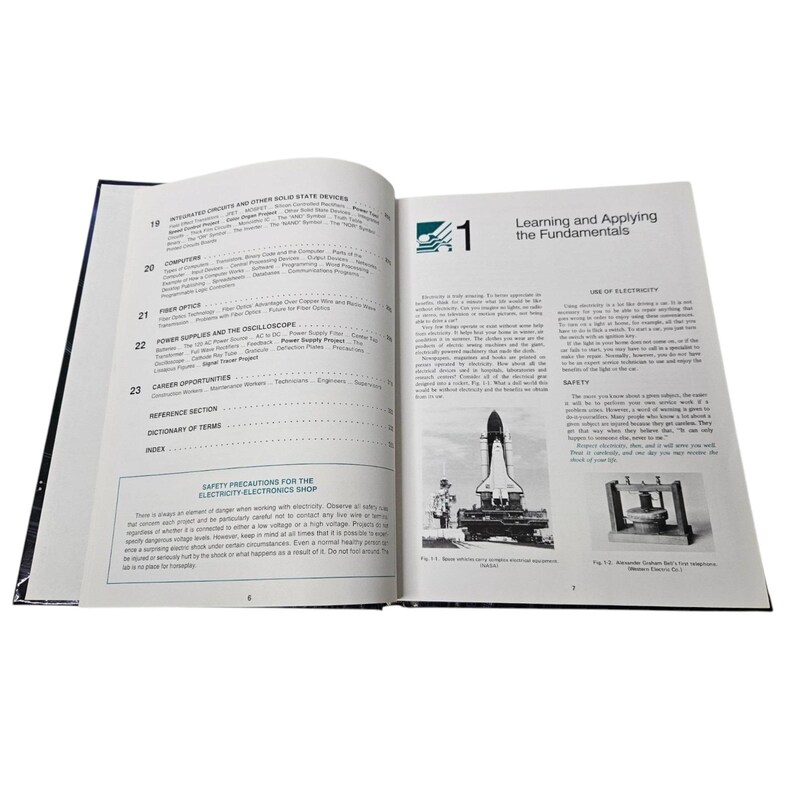 May include: An open book with black and white text and illustrations. The left page has a table of contents, and the right page has the title "Learning and Applying the Fundamentals" with images of a rocket and a device.