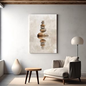 Könnte beinhalten: Leinwanddruck mit einem Stapel glatter, brauner Steine, die sich im Wasser spiegeln. Das Kunstwerk verwendet eine neutrale Farbpalette mit Beige- und Brauntönen und schafft eine ruhige und minimalistische Ästhetik. Das Bild weckt ein Gefühl von Ausgeglichenheit und Ruhe.