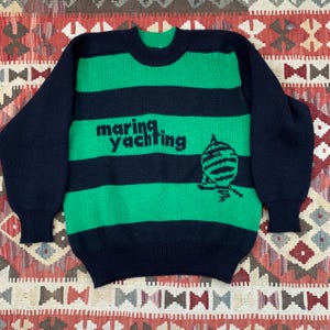 May include: A green and black striped sweater with the text "marine yachting" and a graphic of a sailboat.