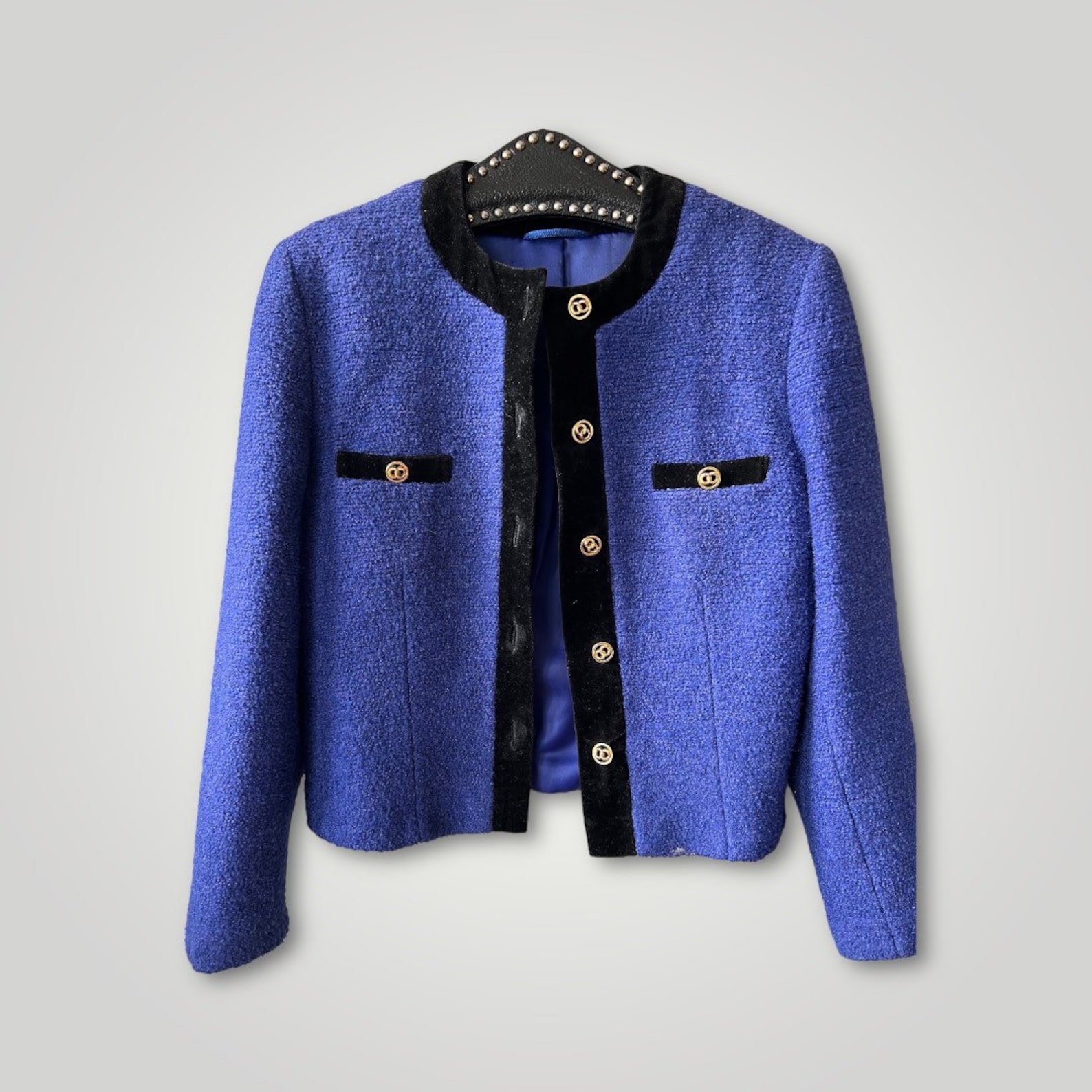 Vintage St Michael’s electric blue tweed boucle wool blazer with pocket detail gold buttons and black velvet trimming. It is in excellent condition and has been dry cleaned.