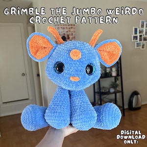 Può includere: Un peluche all'uncinetto blu con grandi orecchie arancioni, due piccole corna arancioni e una piccola macchia arancione sulla fronte. Presenta grandi occhi scuri e lucidi e un piccolo naso arancione. Il testo recita: GRIMBLE THE JUMBO WEIRDO CROCHET PATTERN DIGITAL DOWNLOAD ONLY.