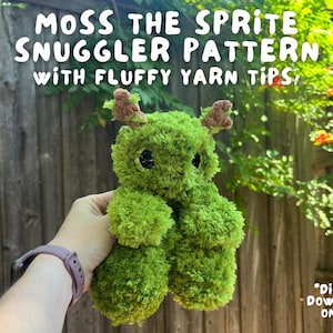 Może przedstawiać: Zielony, puszysty pluszowy sprite z przędzy z brązowymi akcentami, trzymany w dłoni. Pluszak ma duże czarne oczy i etykietę "MOSS THE SPRITE SNUGGLER PATTERN WITH FLUFFY YARN TIPS". Widoczny jest również tekst "DIGITAL DOWNLOAD ONLY!"