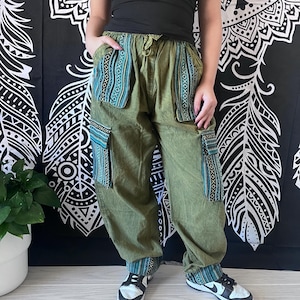 May include: Green cargo pants with blue and white patterned trim around the pockets and cuffs. The pants have a drawstring waist and are made of a soft, comfortable fabric.