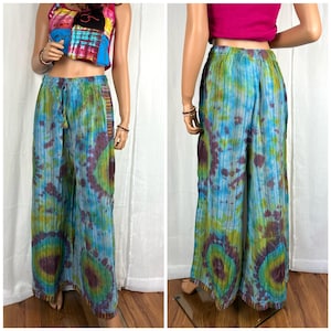 Puede incluir: Pantal&oacute;n de pierna ancha con un patr&oacute;n tie-dye en tonos azules, verdes y morados. El pantal&oacute;n tiene una cintura con cord&oacute;n y un ribete de cuentas en el dobladillo.