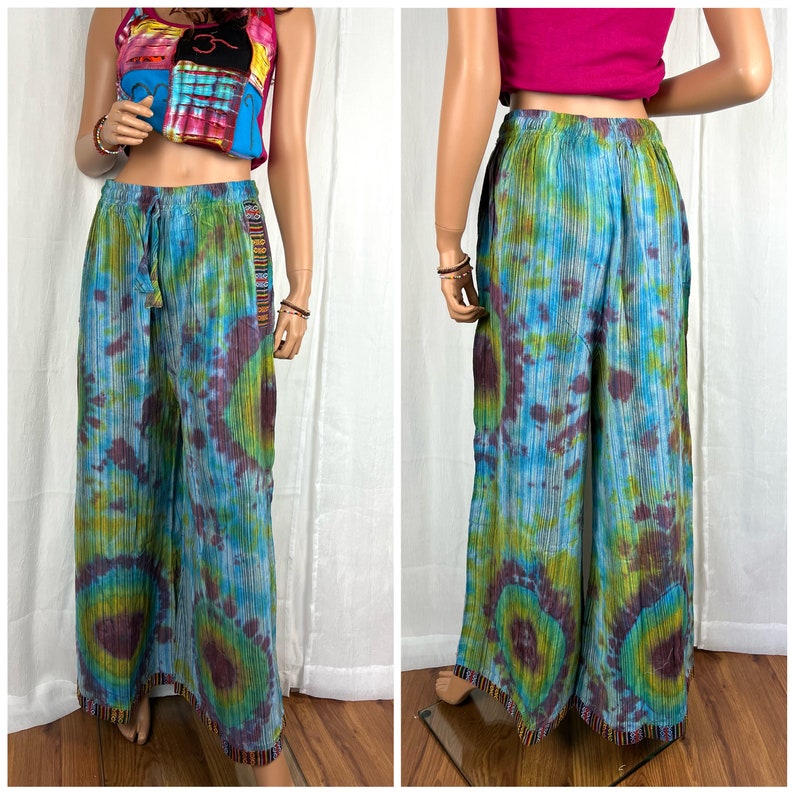 Puede incluir: Pantal&oacute;n de pierna ancha con un patr&oacute;n tie-dye en tonos azules, verdes y morados. El pantal&oacute;n tiene una cintura con cord&oacute;n y un ribete de cuentas en el dobladillo.