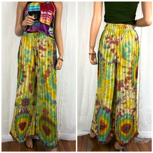 Puede incluir: Pantalones anchos de tie-dye con un esquema de color amarillo, verde y marr&oacute;n. Los pantalones tienen un patr&oacute;n a rayas y una cintura con cord&oacute;n.