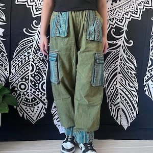 May include: Green cargo pants with blue and white patterned fabric accents on the pockets and cuffs. The pants have a relaxed fit and are made of a soft, comfortable material.