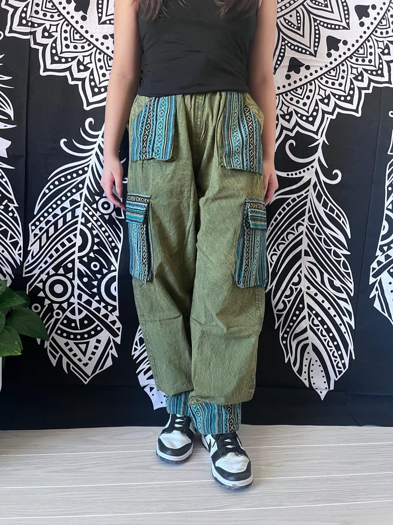 May include: Green cargo pants with blue and white patterned fabric accents on the pockets and cuffs. The pants have a relaxed fit and are made of a soft, comfortable material.
