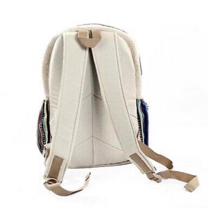 May include: A beige canvas backpack with adjustable straps. The backpack has a colorful striped pattern on the front and sides.