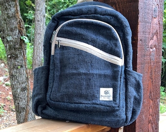 May include: A dark blue canvas backpack with a beige zipper and a small beige patch with the text "PuzzleStack" on the front.