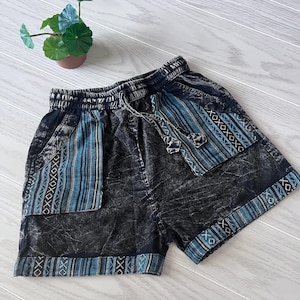 May include: Black denim shorts with blue and white patterned trim. The shorts have a drawstring waist and pockets.