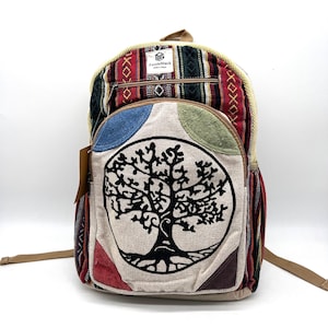 May include: A colorful backpack with a tree of life design. The backpack features a variety of patterns and colors, including red, green, blue, and brown. The brand name "PuzzleStack" is visible on a tag.