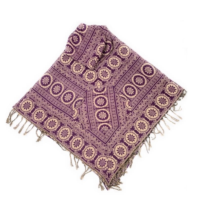 K&ouml;nnte beinhalten: Ein lila- und cremefarbener Schal mit Fransen. Der Schal hat ein geometrisches Muster mit einem sich wiederholenden Muster aus Kreisen und Spiralen.