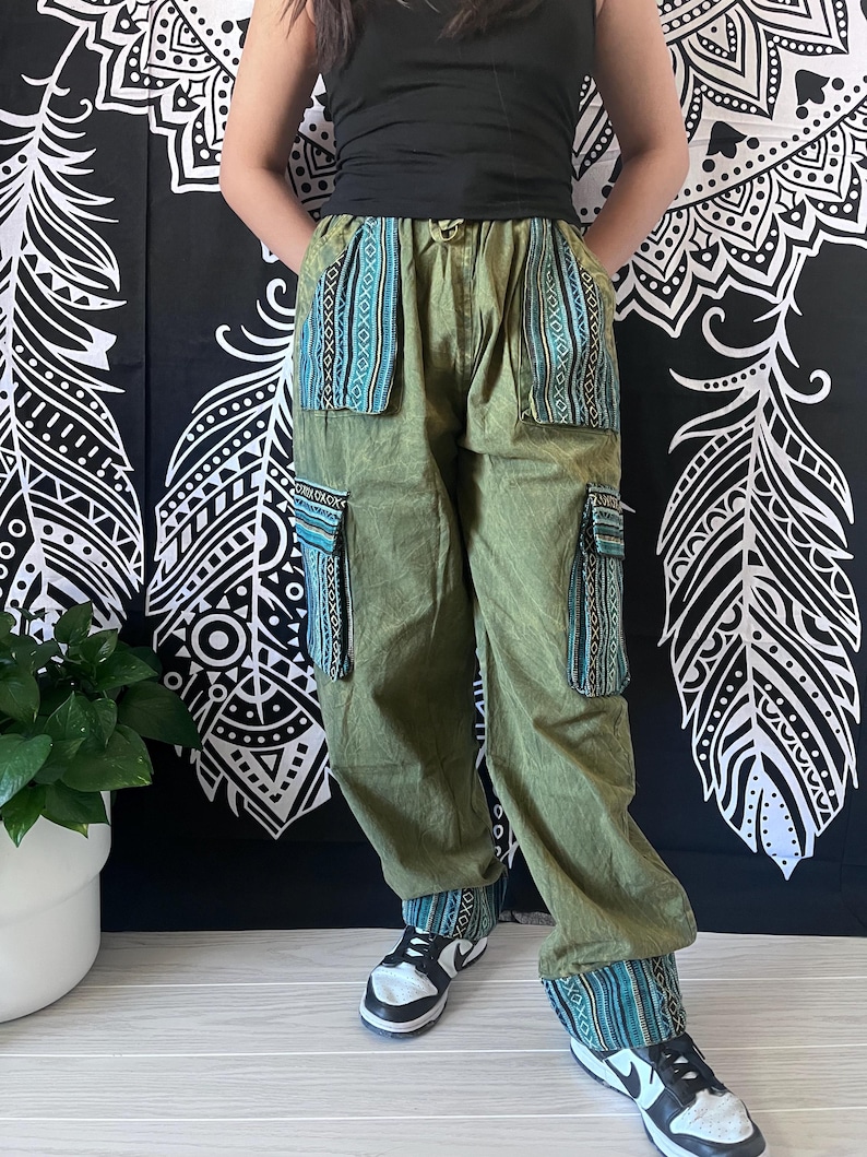 May include: Green cargo pants with blue and green patterned fabric accents on the pockets and cuffs. The pants have a relaxed fit and are made of a lightweight fabric.