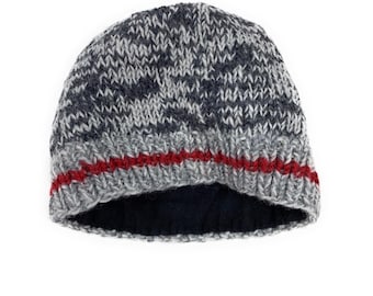 May include: A knitted beanie hat in shades of gray and navy blue with a red stripe near the brim. The hat has a dark blue interior lining. The hat is made of a soft, textured material.