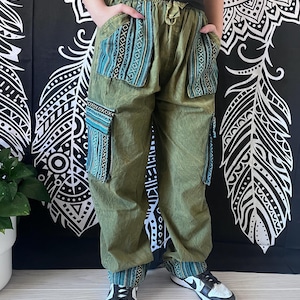 May include: Green cargo pants with blue and black patterned pockets. The pants have a drawstring waist and are made of a soft, comfortable fabric.