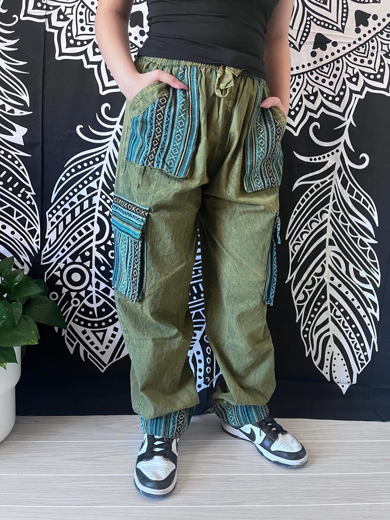 May include: Green cargo pants with blue and black patterned pockets. The pants have a drawstring waist and are made of a soft, comfortable fabric.