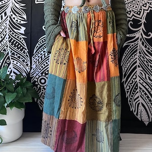 Puede incluir: Una falda de estilo bohemio con estampado de patchwork multicolor. La falda est&aacute; hecha de tela de algod&oacute;n y presenta una variedad de dise&ntilde;os impresos, incluyendo lunas, soles y flores. La falda tiene una cintura con cord&oacute;n y un ajuste holgado.
