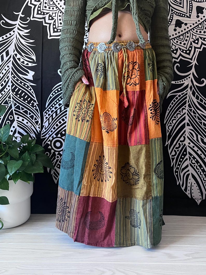 Puede incluir: Una falda de estilo bohemio con estampado de patchwork multicolor. La falda est&aacute; hecha de tela de algod&oacute;n y presenta una variedad de dise&ntilde;os impresos, incluyendo lunas, soles y flores. La falda tiene una cintura con cord&oacute;n y un ajuste holgado.