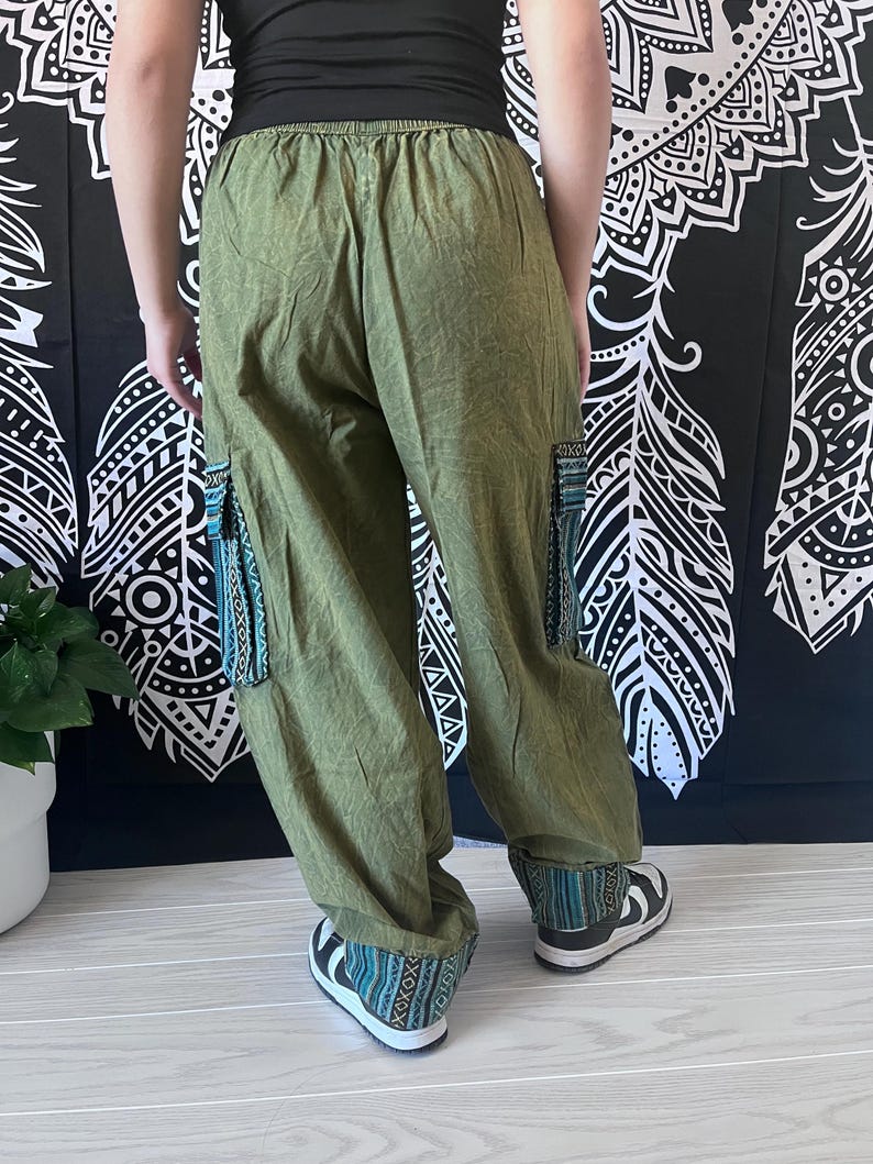 May include: Green cargo pants with a drawstring waist and embroidered details on the legs and cuffs.