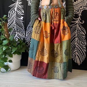 Puede incluir: Una falda larga de retazos multicolor con estampado floral. La falda est&aacute; hecha de diferentes telas y tiene un estilo bohemio.
