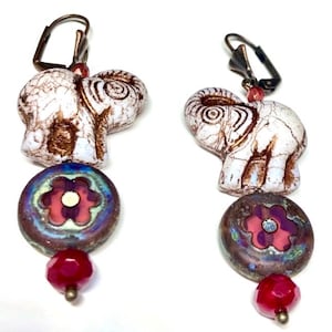 Antique ivory with copper wash Czech glass elephant bead dangle earrings adorned with orchid pink floral beads with an antique stone look.