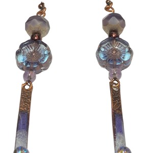 Purple with gold wash transparent hibiscus bead earrings adorned by artisan made purple on copper dangles with a transparent lavender bead.