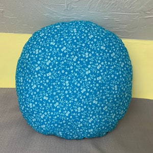 Reversible round decorative pillow.