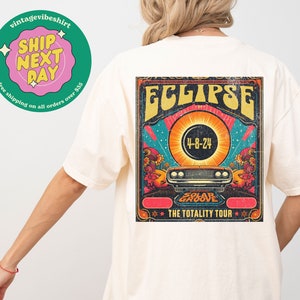 May include: A vintage-style graphic t-shirt with a colorful illustration of a solar eclipse and the text "ECLIPSE" and "THE TOTALITY TOUR".