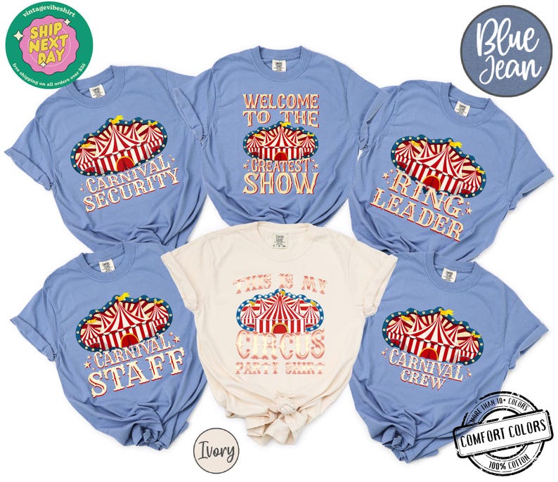 May include: A collection of blue and ivory t-shirts with circus-themed designs. The shirts feature text like "Carnival Security," "Welcome to the Greatest Show," and "This is My Circus Party Shirt." The designs include a red and white circus tent.