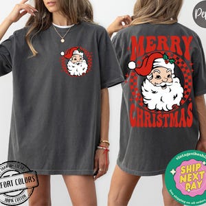May include: A gray t-shirt with a red and white retro design featuring a cartoon Santa Claus with the text "Merry Christmas".