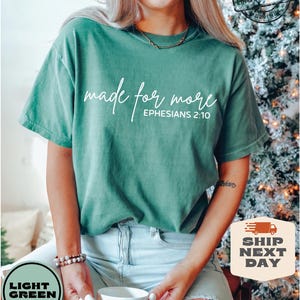 Puede incluir: Una camiseta verde claro con el texto "made for more" y "EPHESIANS 2:10" en letras blancas.