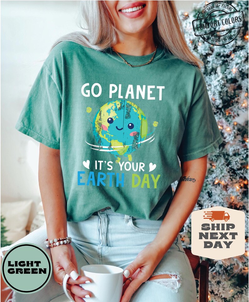 May include: A light green t-shirt with the text "Go Planet" and a cartoon image of the Earth with a smiling face. The text "It's Your Earth Day" is below the image.