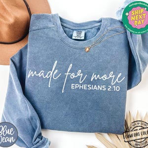 Puede incluir: Una sudadera de mezclilla azul con el texto "made for more" y "EPHESIANS 2:10" en blanco.