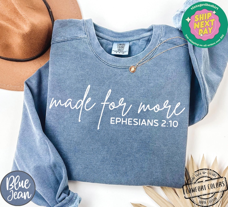 Puede incluir: Una sudadera de mezclilla azul con el texto "made for more" y "EPHESIANS 2:10" en blanco.